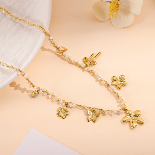 Collier doré à perles fines et charms floraux
