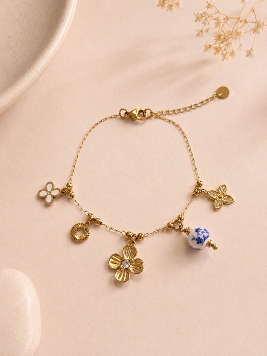 Bracelet doré à charms floraux et porcelaine bleue