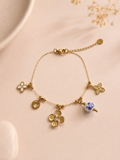 Bracelet doré à charms floraux et porcelaine bleue